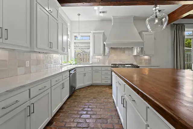 Kitchen with custom cabinetry, gas cooktop and vent hood