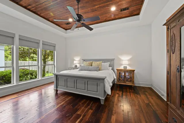 Primary bedroom with plank ceiling and wide-plank floors